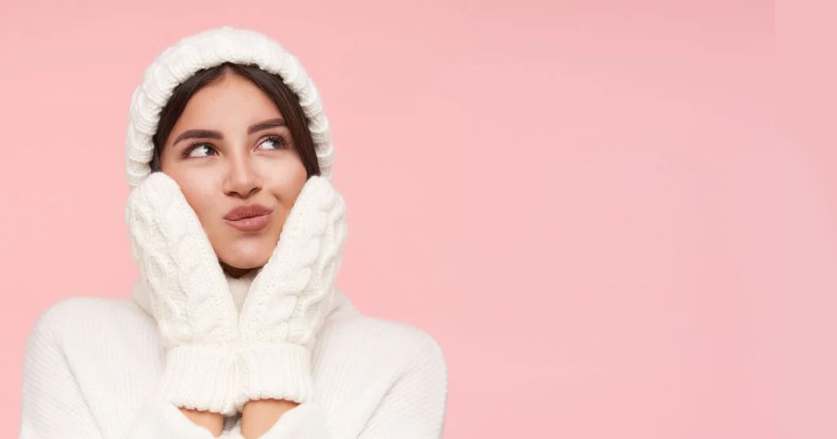 mulher vestida de touca e luvas de lã para representar os cuidados da pele no inverno